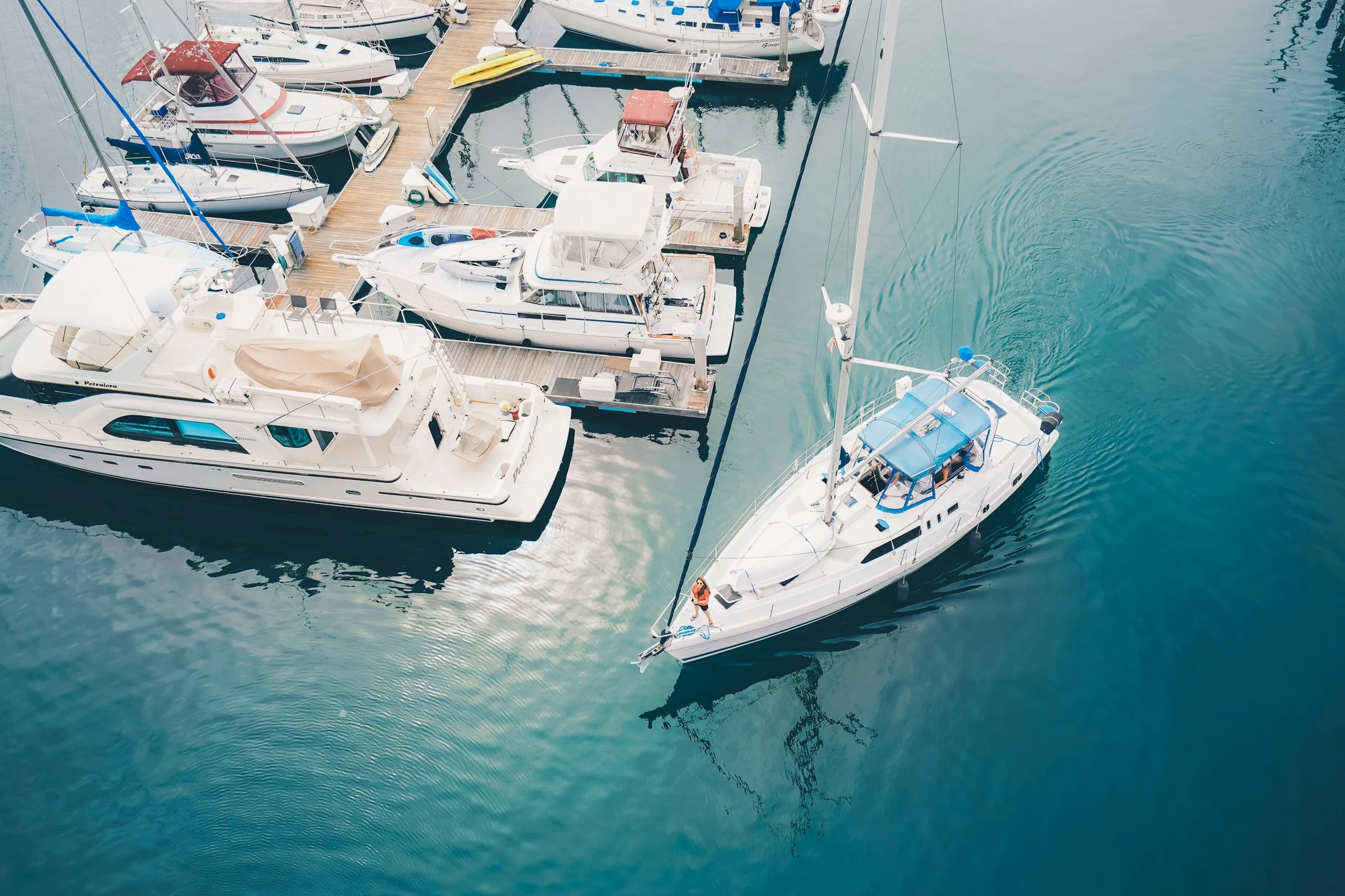 Yachts in a sunny marina with clear turquoise water